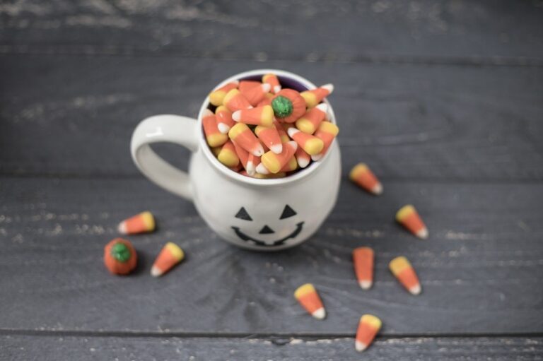 Halloween mug full of candy corn on a wooden floor